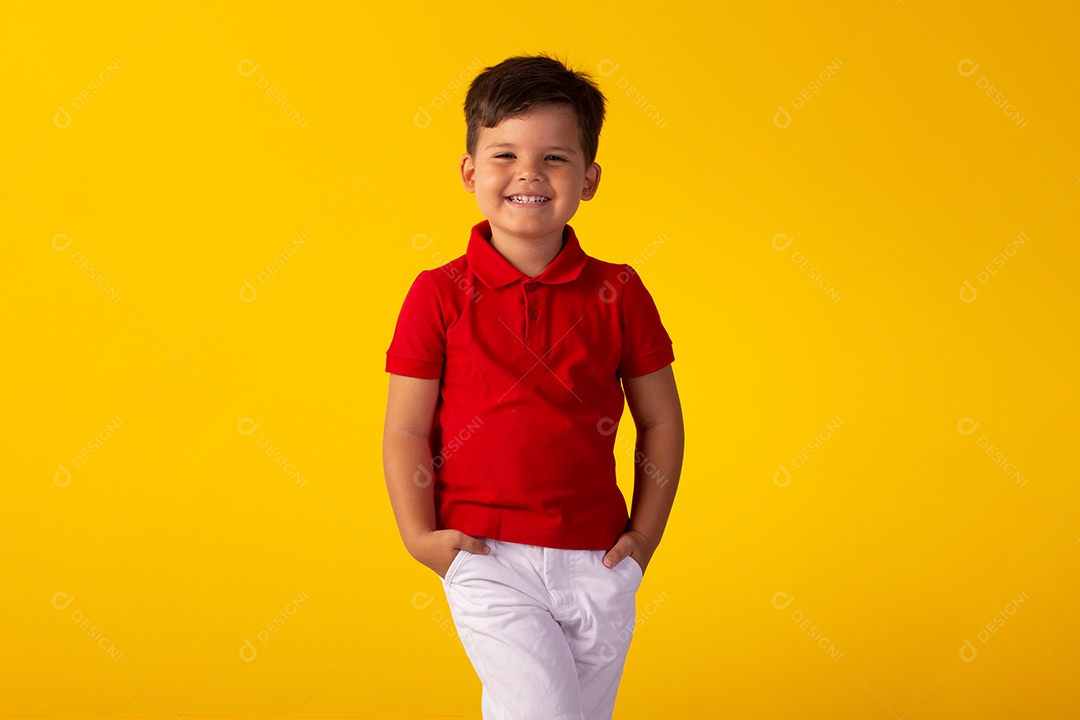 Criança do sexo masculino em foto de estúdio com fundo claro vestindo camisa e jeans