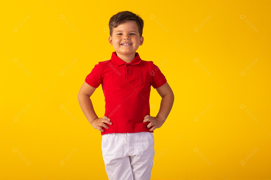 Criança do sexo masculino em foto de estúdio com fundo claro vestindo camisa e jeans
