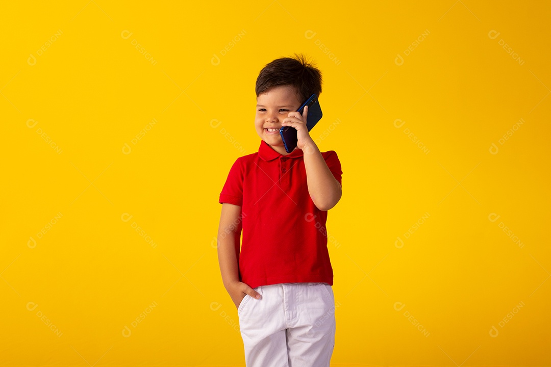 Criança do sexo masculino em foto de estúdio com fundo claro vestindo camisa e jeans