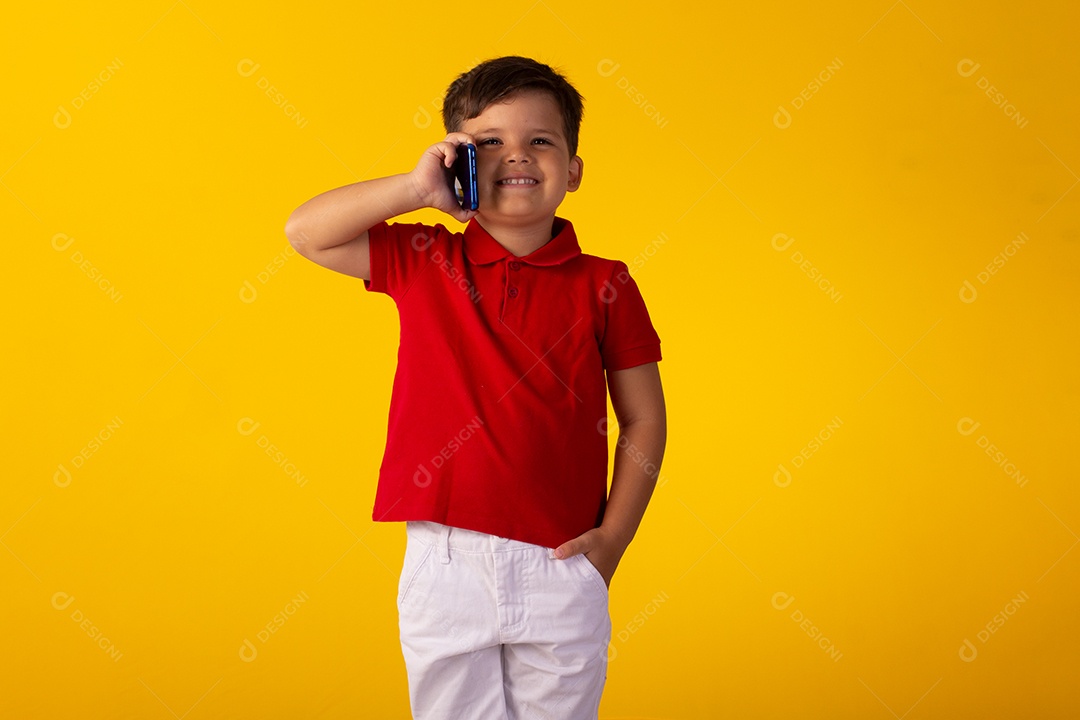 Criança do sexo masculino em foto de estúdio com fundo claro vestindo camisa e jeans