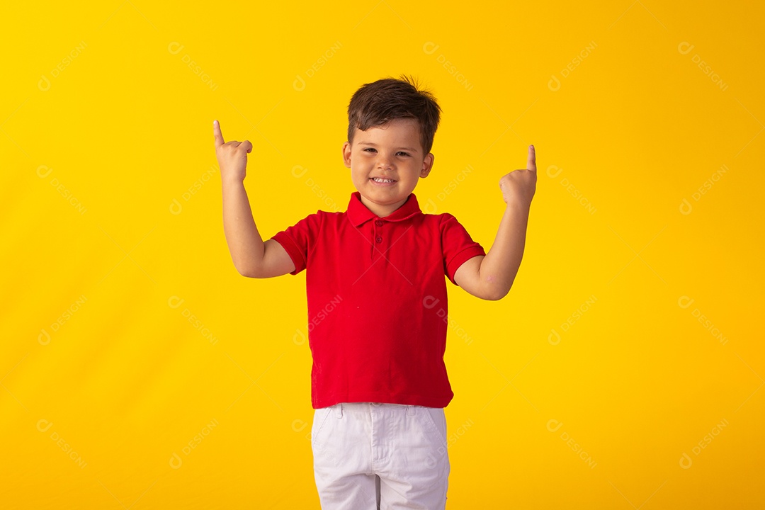 Criança do sexo masculino em foto de estúdio com fundo claro vestindo camisa e jeans