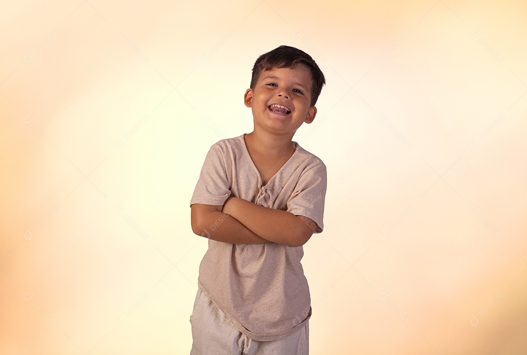 Criança do sexo masculino em foto de estúdio com fundo claro vestindo camisa e jeans