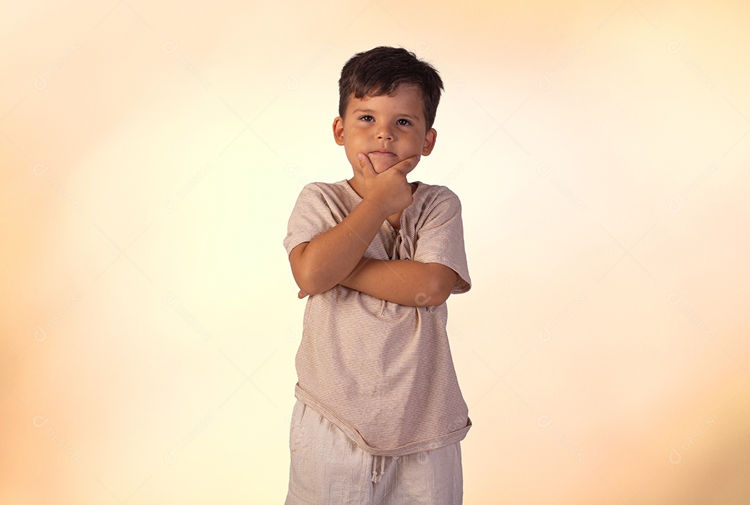 Criança do sexo masculino em foto de estúdio com fundo claro vestindo camisa e jeans