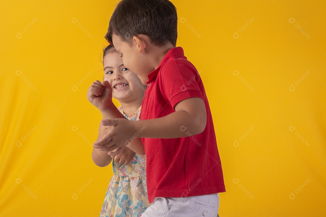 Duas crianças um menino e uma menina se abracando e brincando
