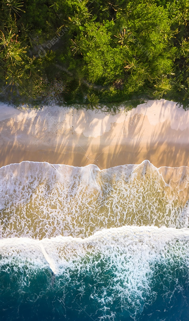 Vista aérea de drone das ondas do oceano na praia com a luz do pôr do sol