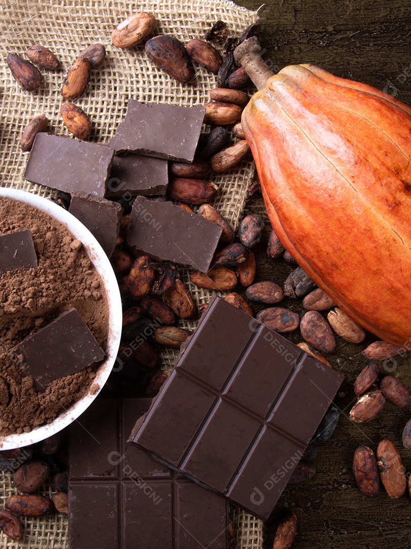 Chocolate amargo com grãos de cacau crus e cacau em pó sobre fundo de juta rústica