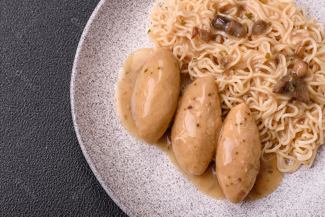 Prato de macarrão com carne em uma mesa de concreto