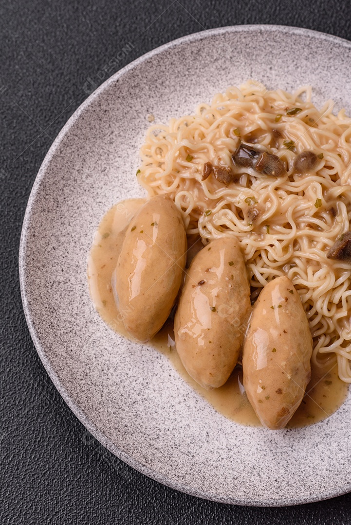 Prato de macarrão com carne em uma mesa de concreto