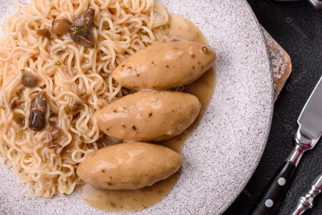 Prato de macarrão com carne em uma mesa de concreto