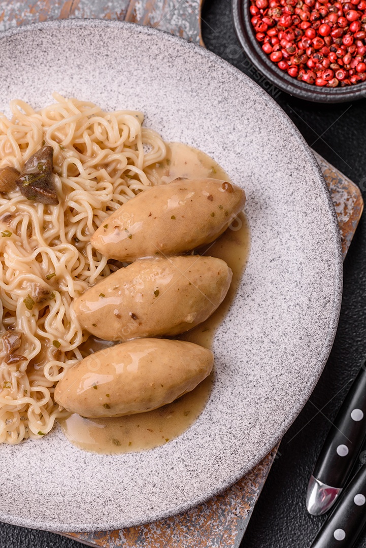Prato de macarrão com carne em uma mesa de concreto