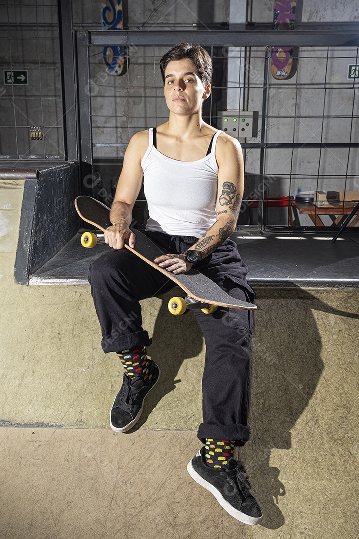 Uma garota brasileira de 26 anos sentada no convés segurando seu skate