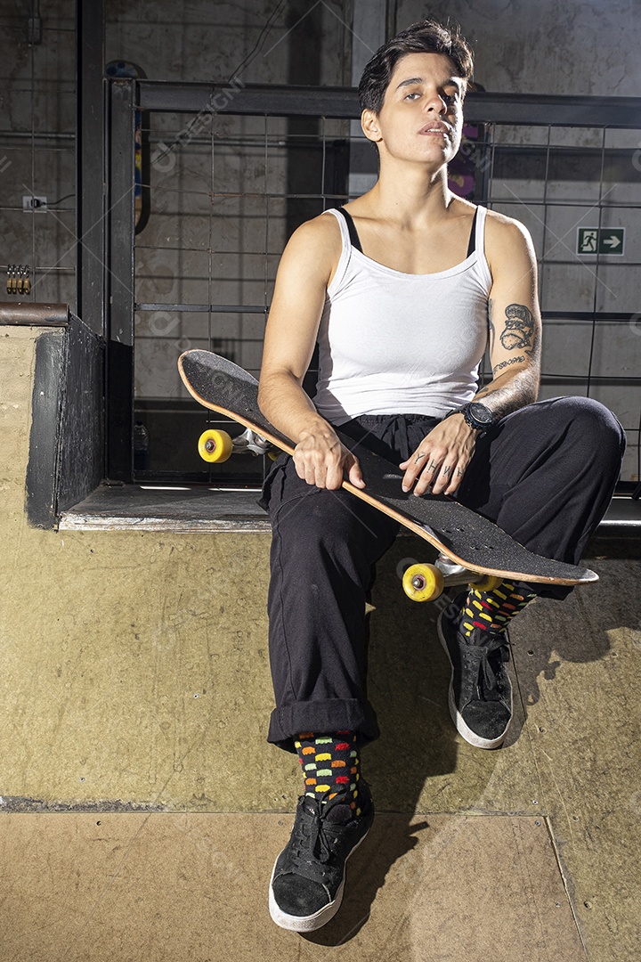 Uma garota brasileira de 26 anos sentada no convés segurando seu skate