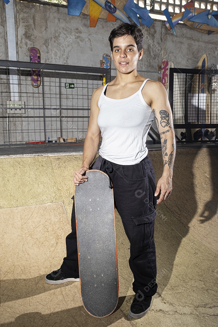 Brasileira de 26 anos no bowl com um skate exibindo seus músculos