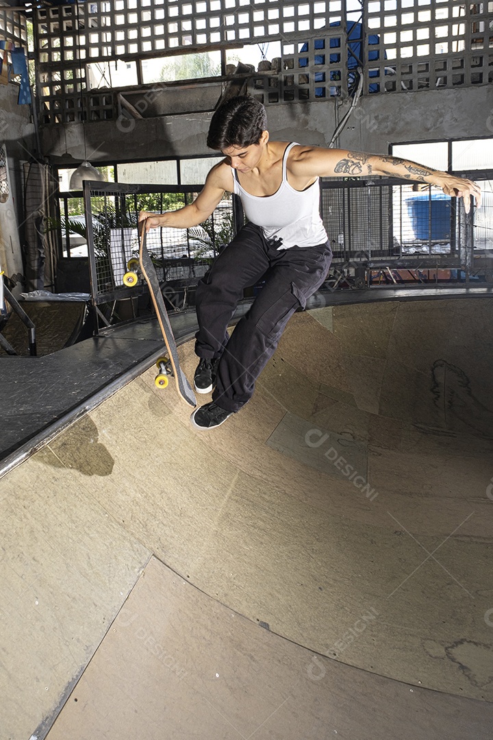 Brasileira de 26 anos no bowl com um skate exibindo seus músculos