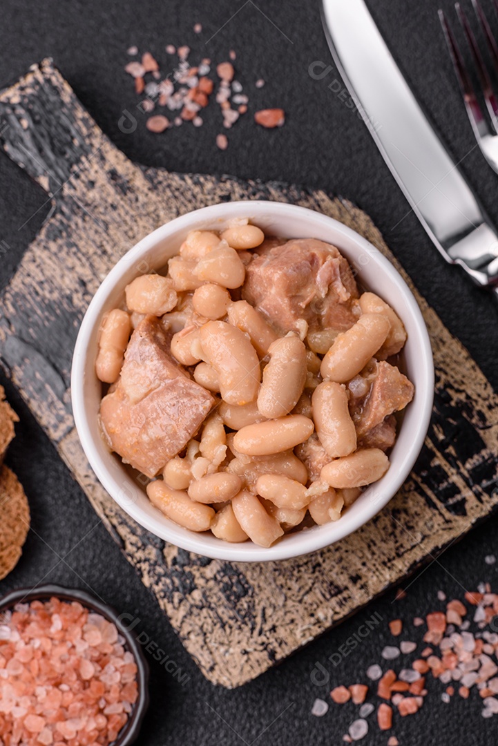 Feijões crus, secos, vermelhos e brancos, sobre um fundo de concreto escuro. Cozinhando Alimentos Saudáveis