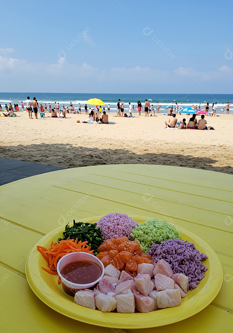 Bela refeição sobre mesa de plástico em uma linda praia com banhistas
