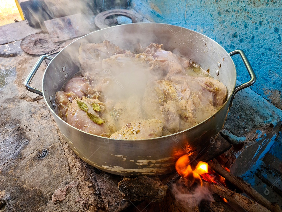 Frango caipira cozinhando na panela fogão caipira