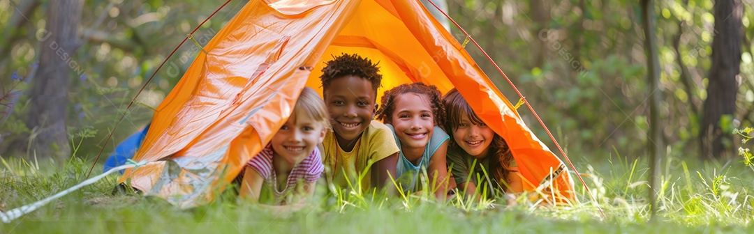 Foto panorâmica de crianças multiculturais felizes sorrindo enquanto estão deitadas perto do acampamento