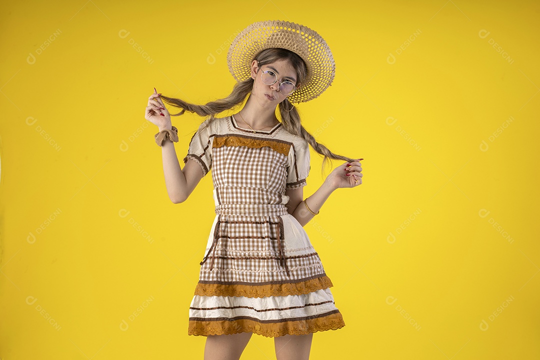 Jovem bonita usando trajes juninos e acessórios de palha