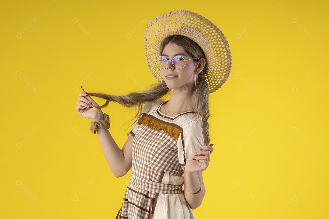 Jovem bonita usando trajes juninos e acessórios de palha