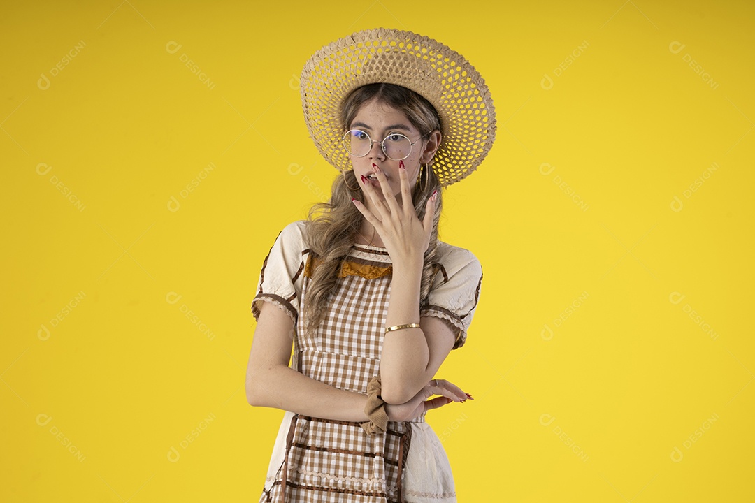 Mulher jovem usando roupas tipicas de festa junina e usando um chapeu de couro