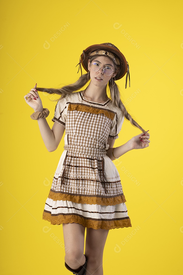 Jovem bonita com trajes de festa junina usando vestido chapéu