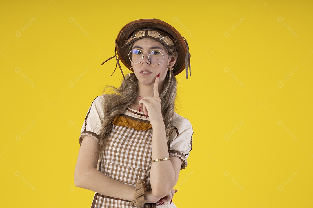 Jovem seria com trajes junino sobre fundo amarelo