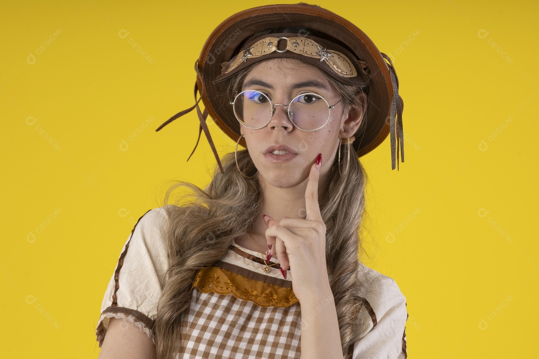 Jovem seria com trajes junino sobre fundo amarelo