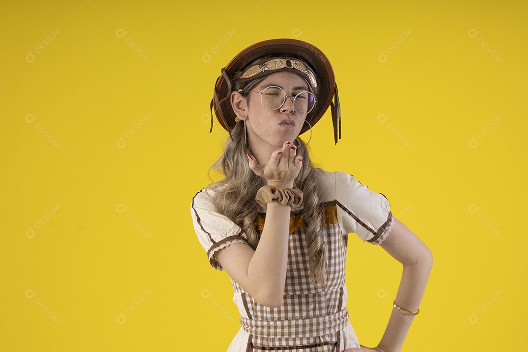 Jovem com trajes juninos mandando beijo para fotografia