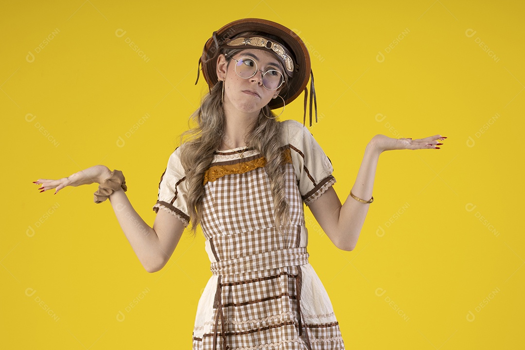 Jovem com gesto de mãos para o lado e trajes juninos típicos de são joão