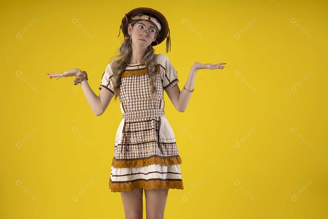 Jovem com gesto de mãos para o lado e trajes juninos típicos de são joão