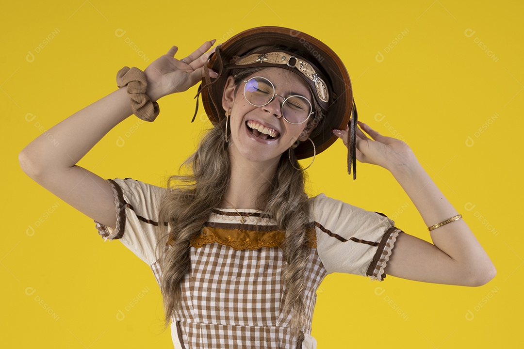 Jovem feliz com trajes típicos de festa junina com mãos na cabeça