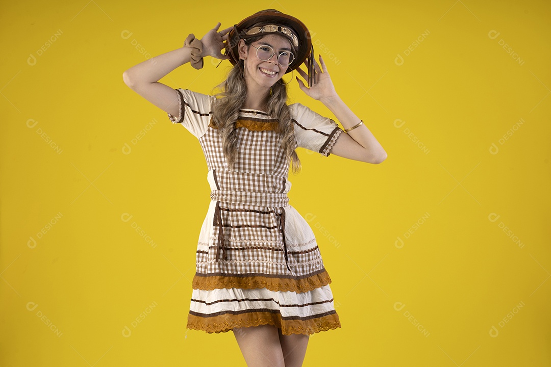 Jovem feliz com trajes típicos de festa junina com mãos na cabeça