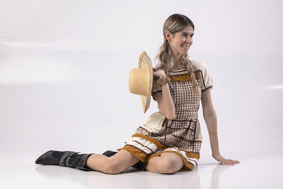 Jovem loira usando um vestido de festa junina com chapéu de palha