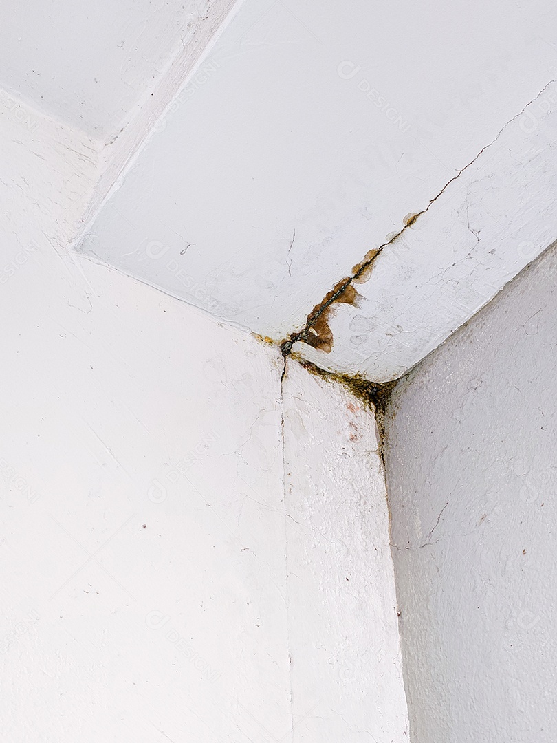 Canto do teto com danos causados ​​pela água e rachaduras