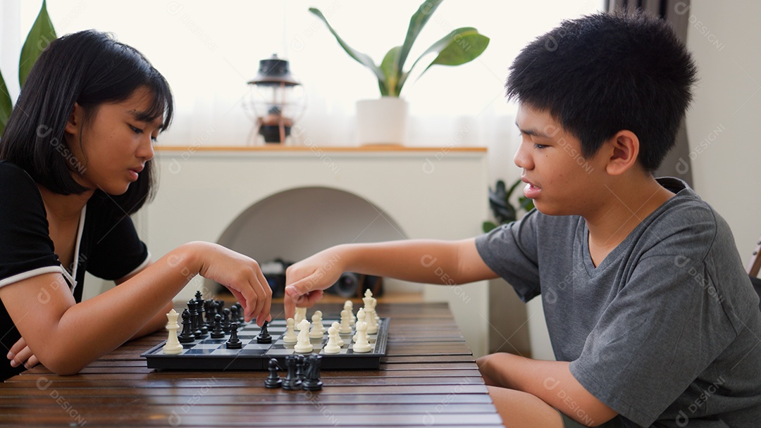 Adolescentes asiáticos jogando xadrez em casa