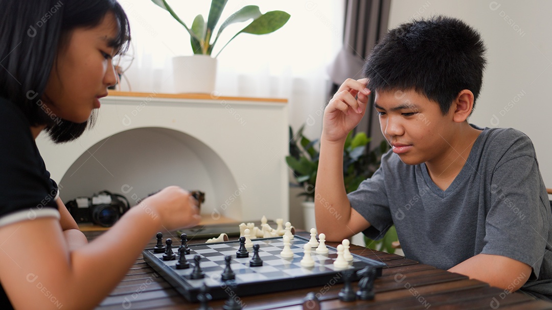 Adolescentes asiáticos jogando xadrez em casa