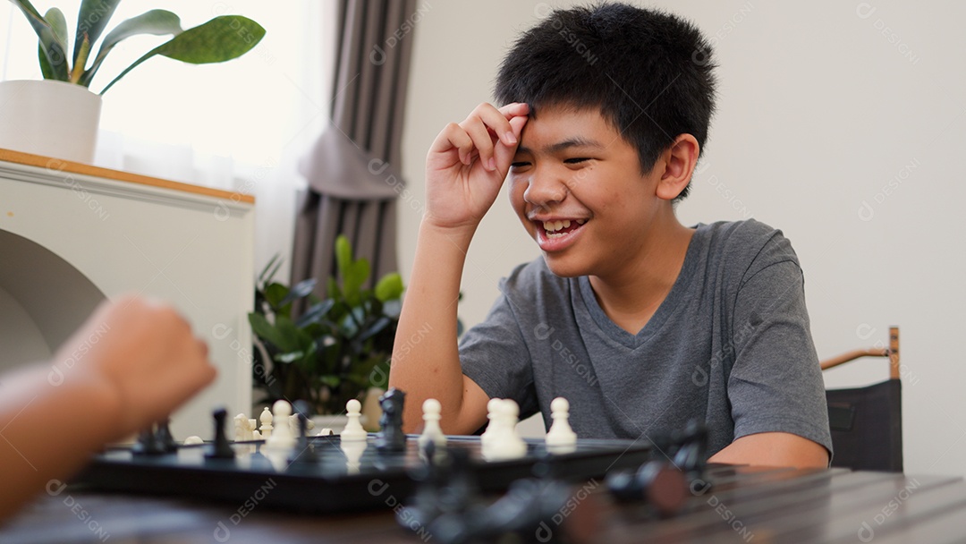 Adolescentes asiáticos jogando xadrez em casa