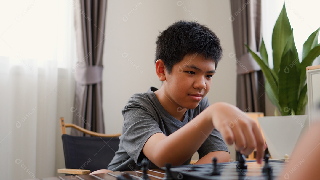 Adolescentes asiáticos jogando xadrez em casa