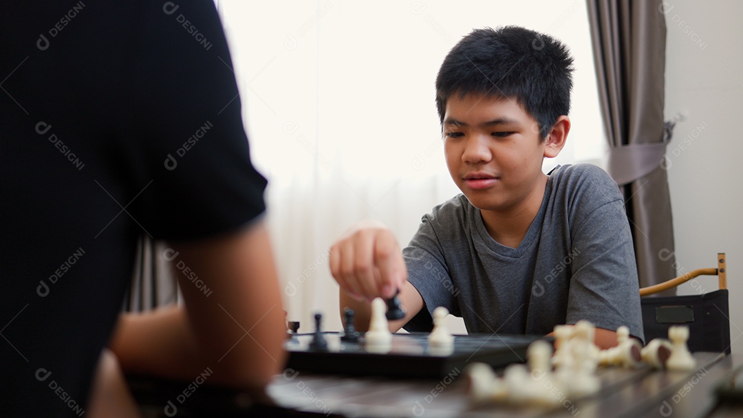 Adolescentes asiáticos jogando xadrez em casa