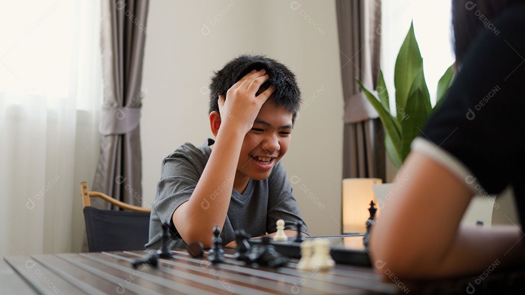 Adolescentes asiáticos jogando xadrez em casa