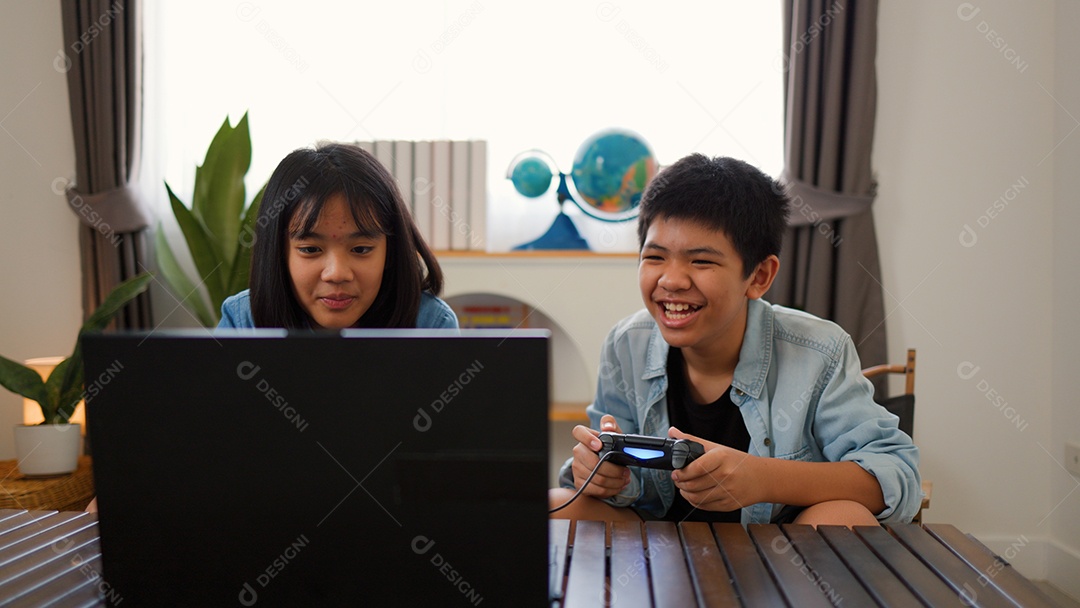 Adolescente asiático e menina jogando videogame juntos em casa