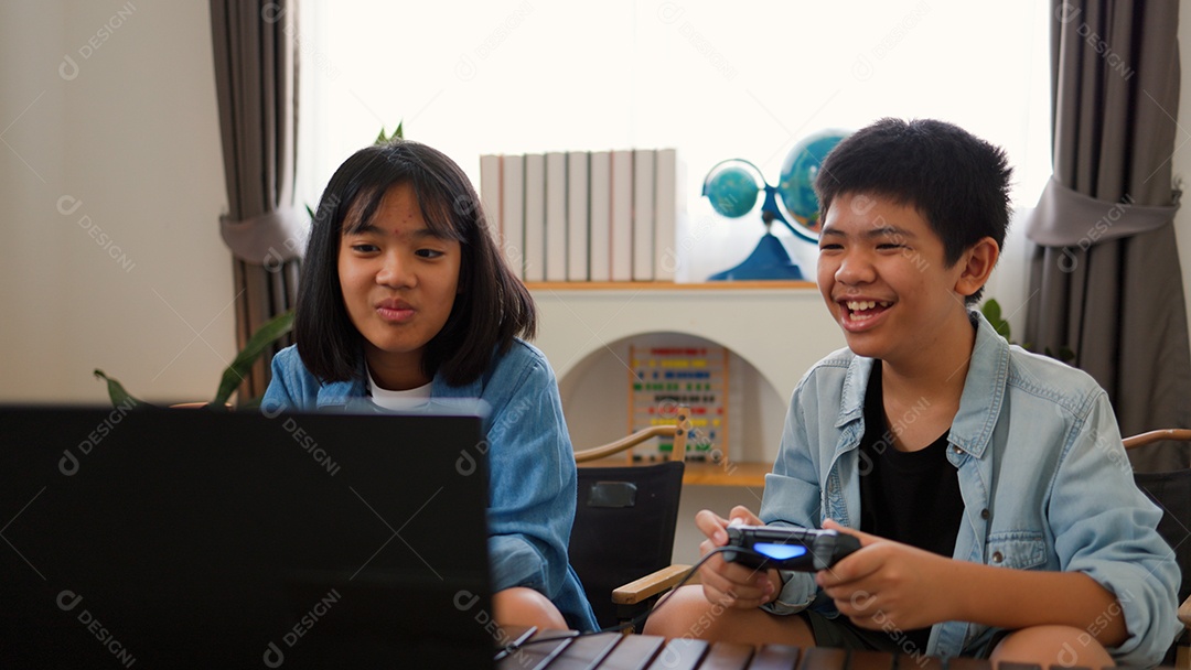 Adolescente asiático e menina jogando videogame juntos em casa