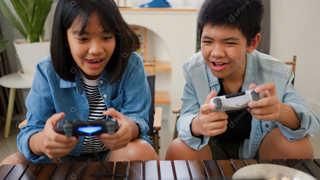 Adolescente asiático e menina jogando videogame juntos em casa
