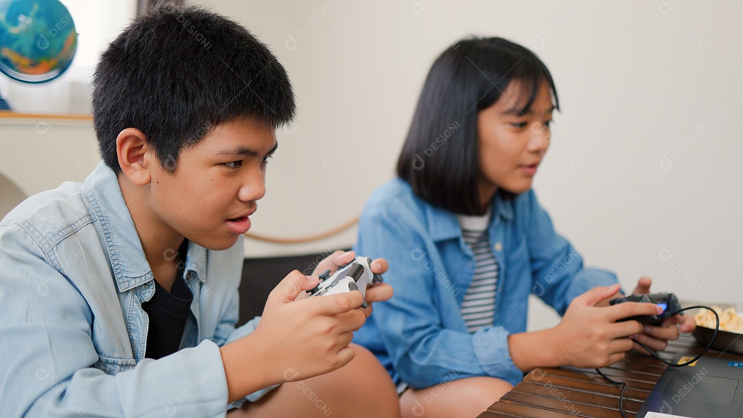 Adolescente asiático e menina jogando videogame juntos em casa