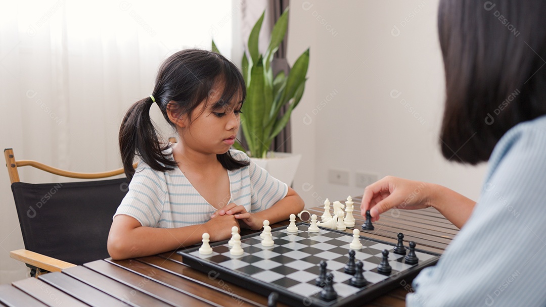 Duas garotas asiáticas jogando xadrez em casa