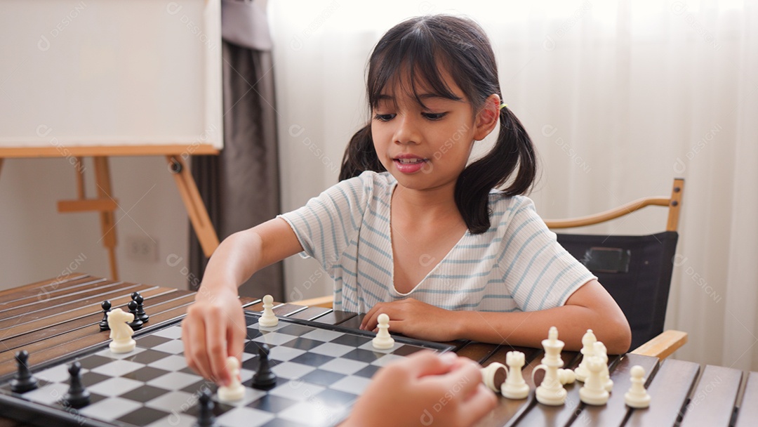 Duas garotas asiáticas jogando xadrez em casa