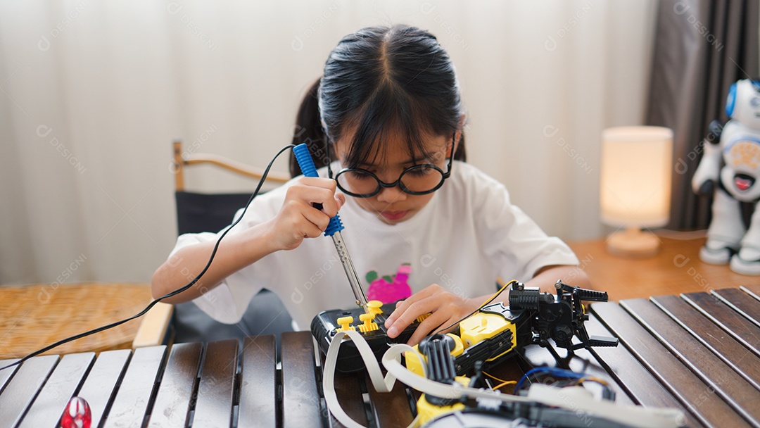 Garota asiática montando peças de robô em casa
