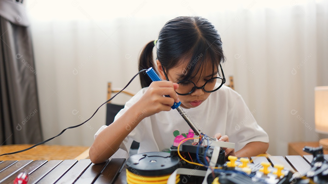 Garota asiática montando peças de robô em casa