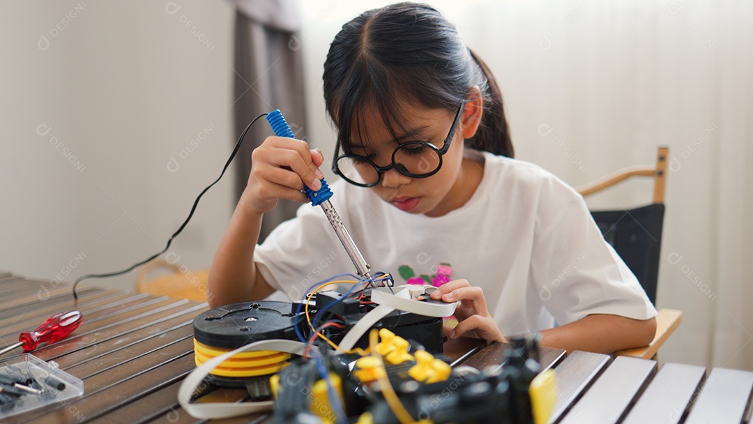 Garota asiática montando peças de robô em casa